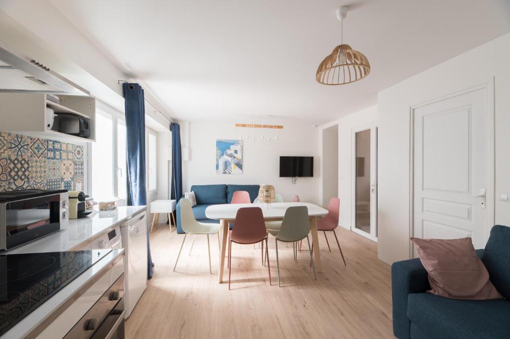 cocina y sala de estar con mesa y sillas en Villa Poncelet, en París