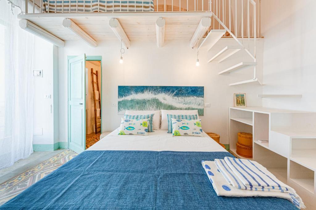 a bedroom with a bed with blue sheets and pillows at VERDEACQUA CASA VACANZE in Morciano di Leuca