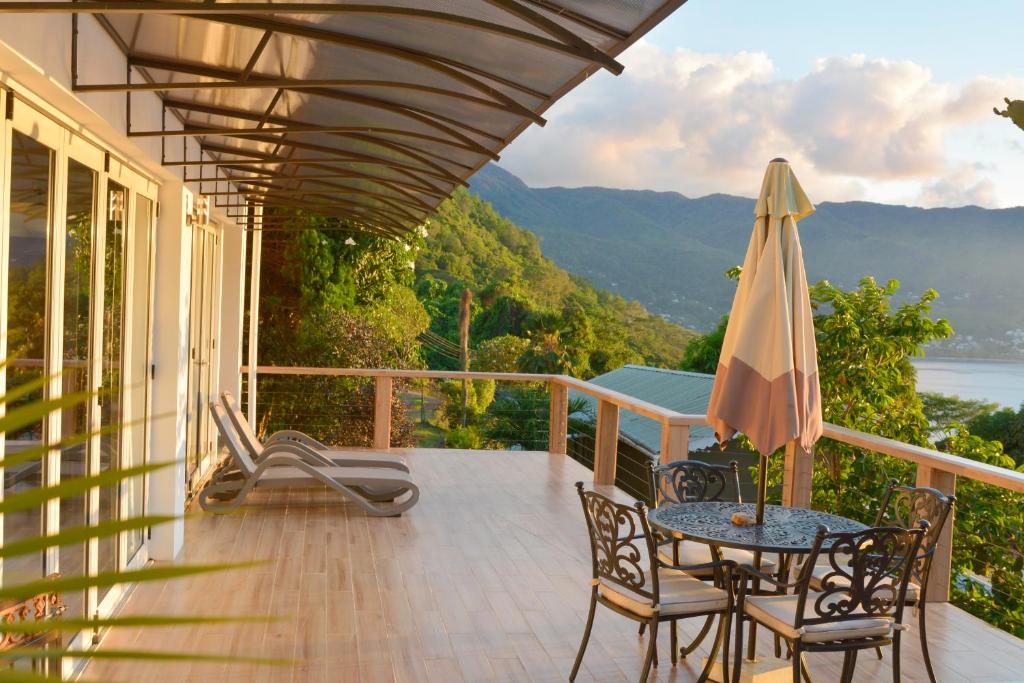 a balcony with an umbrella and a table and chairs at Sunset Bay Apartment in Glacis