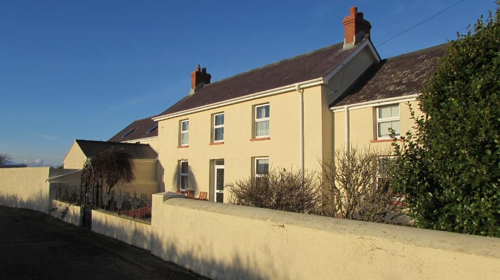 a large white house with a white wall at Little Hilton Farm in Haverfordwest