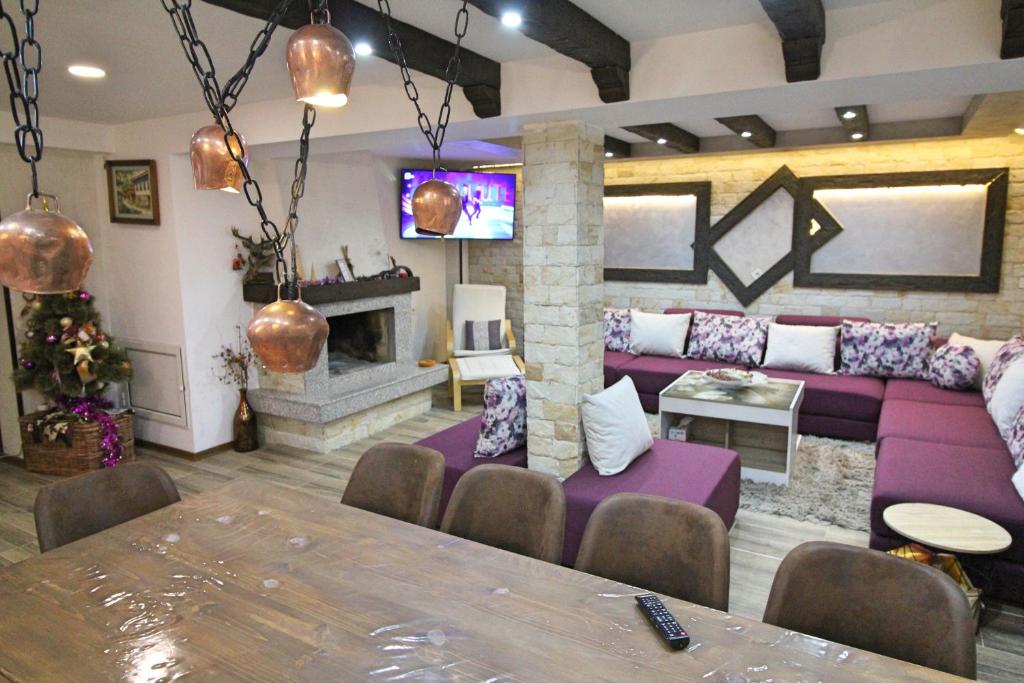 a living room with a purple couch and a fireplace at Ice Jewel Chalet, Bansko, 200 meters from the Gondola, 20 улица „Свети Иван Рилски“ in Bansko