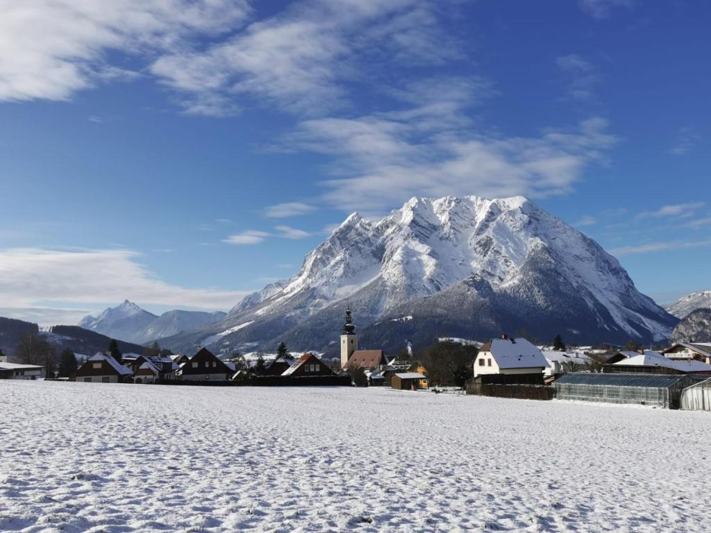 a snow covered mountain in front of a town with a mountain at Wohlfühl - Appartement Fewo Pichlarn Irdning Ferienwohnung in Aigen im Ennstal