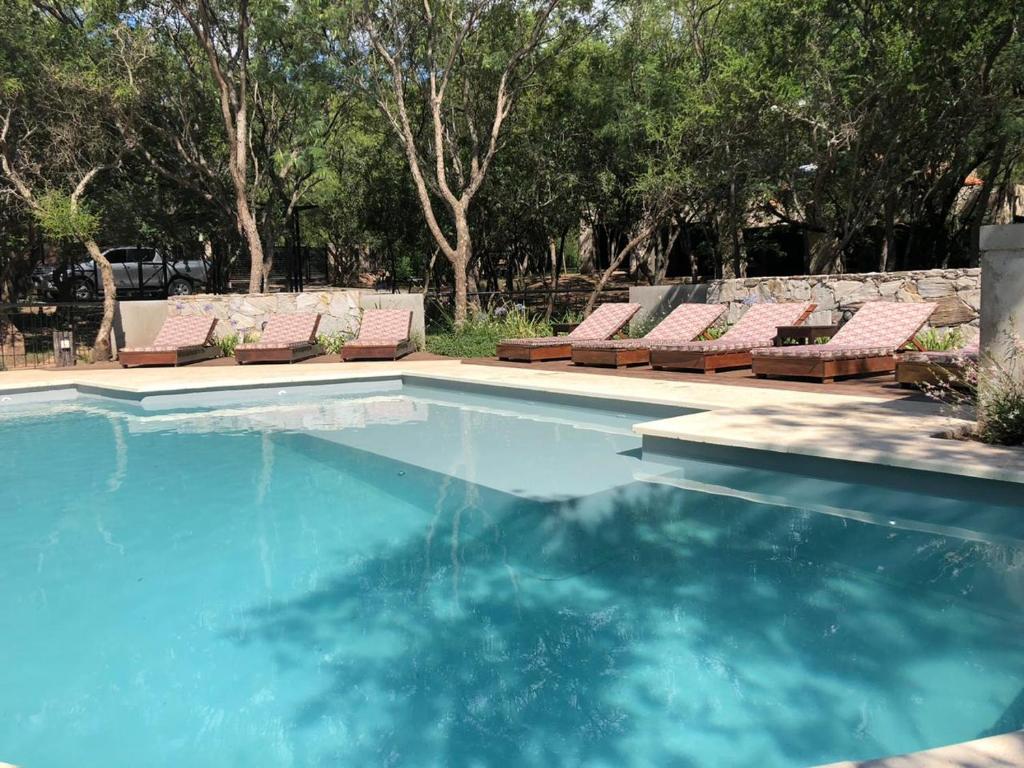 a swimming pool with chaise lounge chairs and a swimming pool at Cabañas Apart Margaridas in Merlo