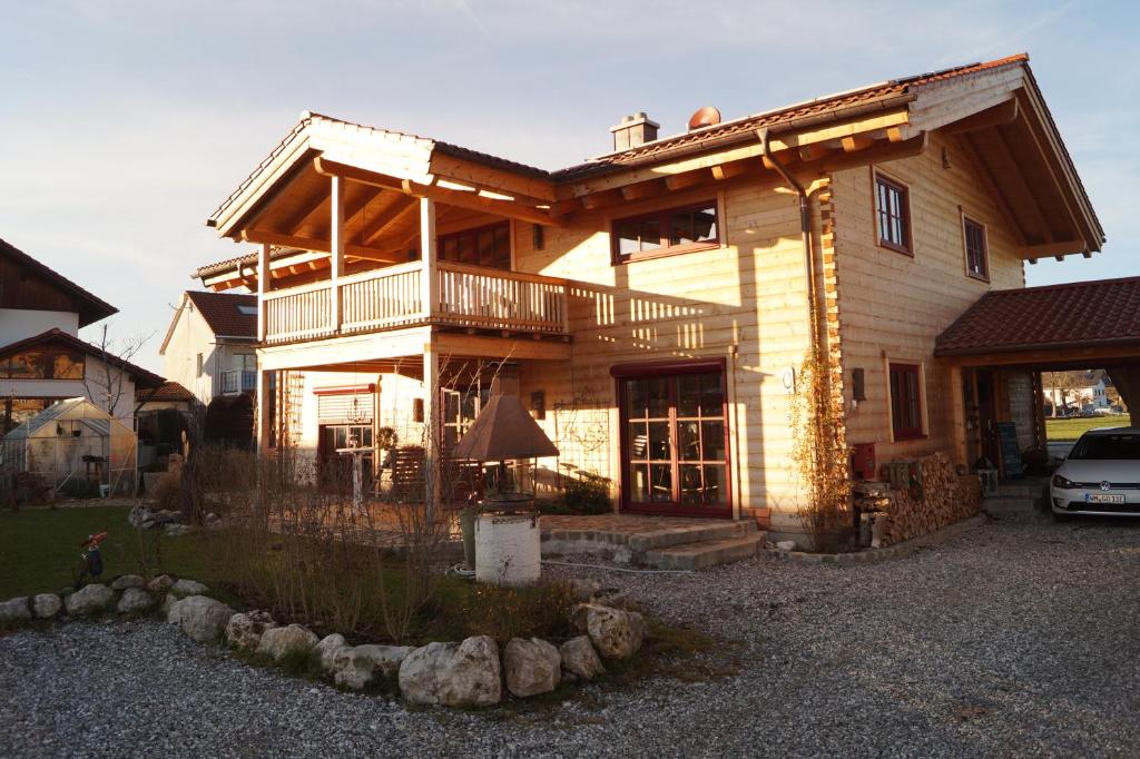 ein großes Holzhaus mit einem davor geparkt in der Unterkunft Ferienwohnung im gemütlichen Blockhaus vor den Bergen in Wielenbach