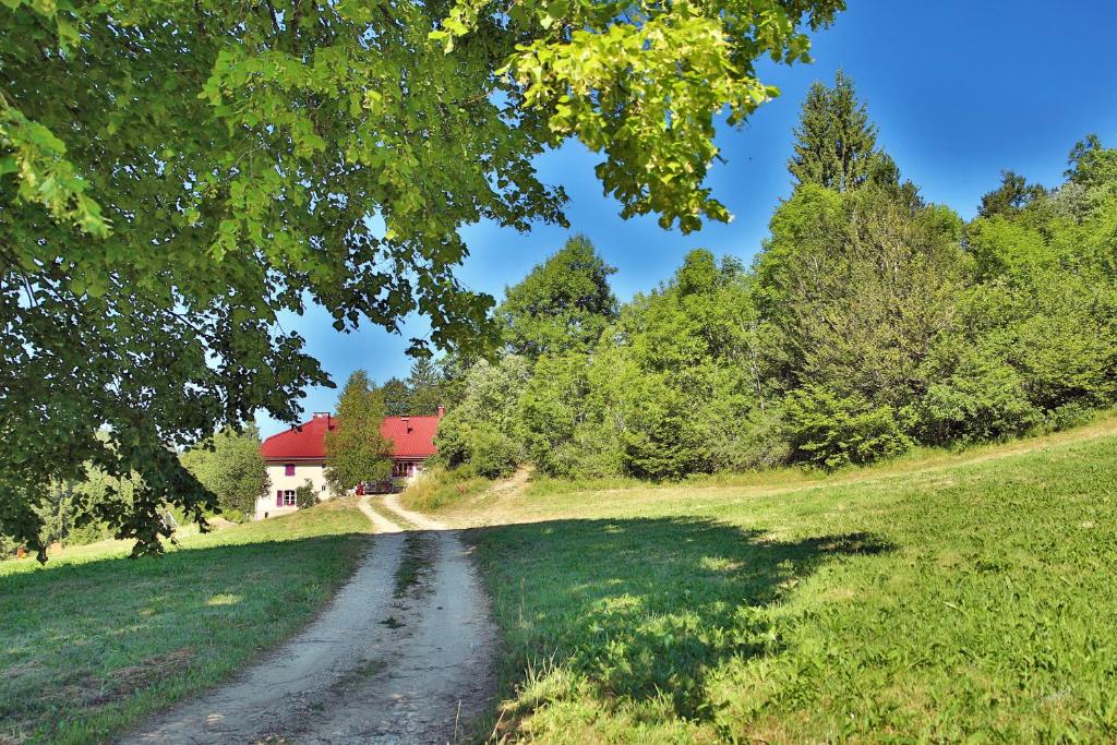 un camino de tierra que conduce a una casa en un campo en Ch'tit Jura, en Les Moussières