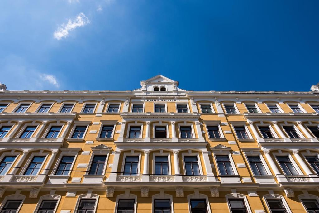 a yellow building with a blue sky in the background at Pension Lehrerhaus in Vienna