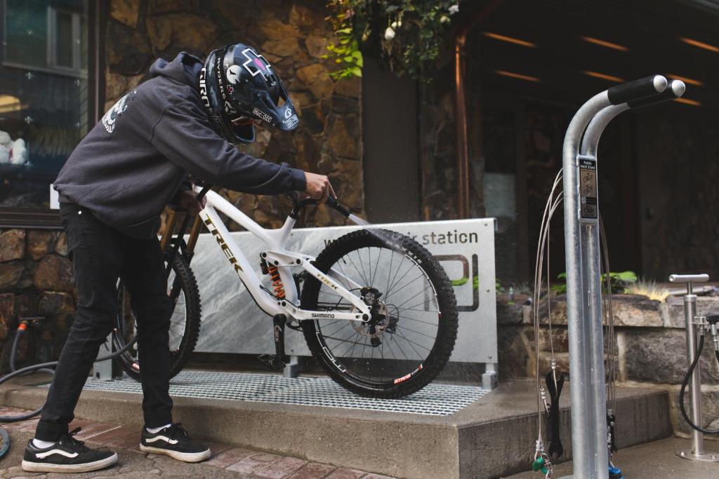 a man in a helmet is holding a bike at Pangea Pod Hotel in Whistler