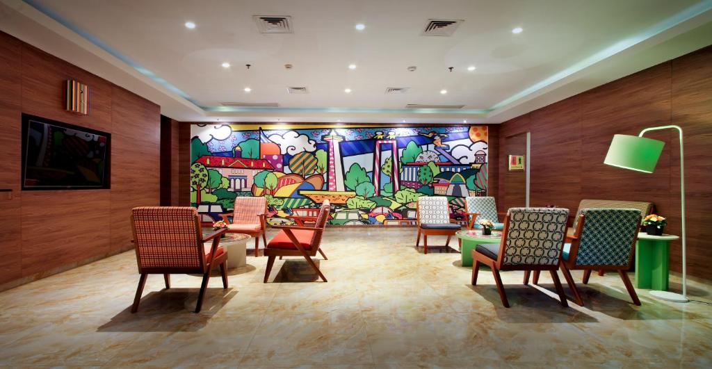 a room with chairs and a painting on the wall at MaxOneHotels.com at Pemuda in Jakarta