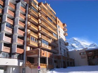 a large building in the snow with a mountain at Residence Le Lac Blanc in Val Thorens