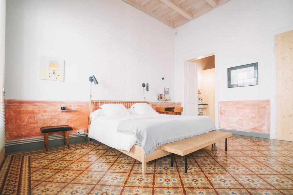 a bedroom with a large white bed and a table at Hotel Hevresac Singular & Small in Mahón