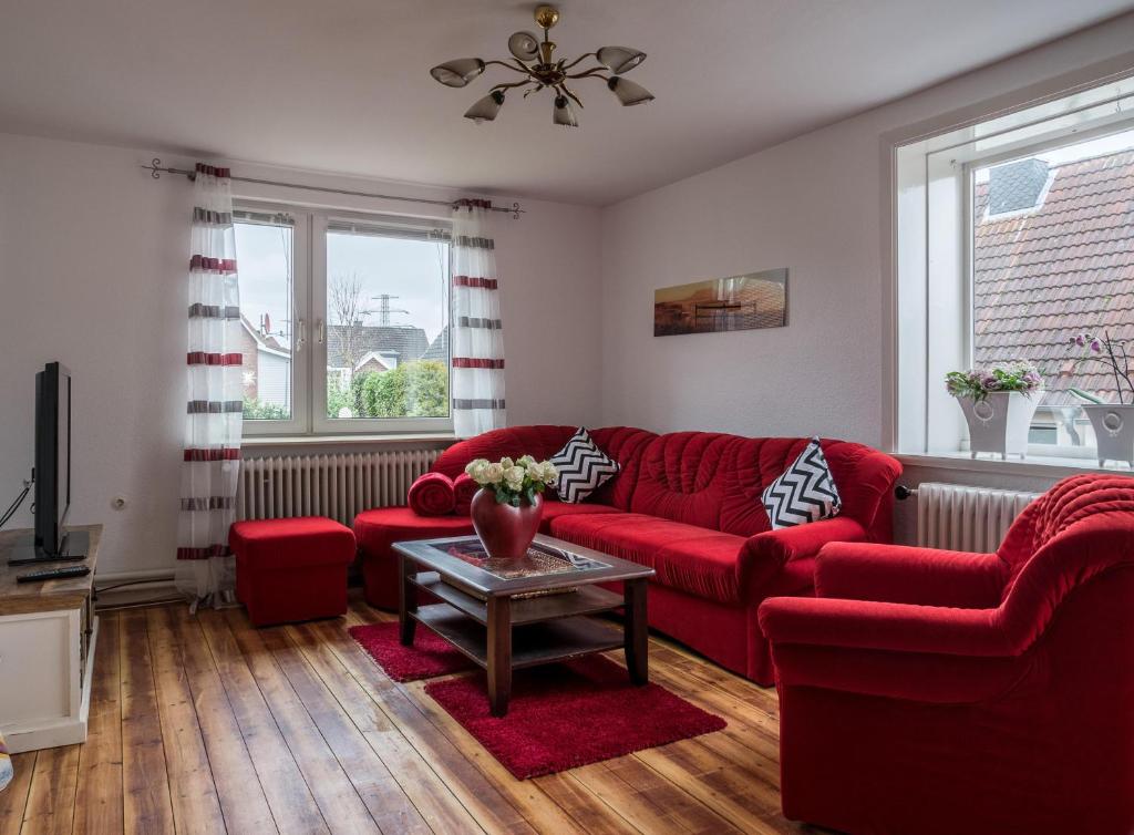 Wohlfühlen in Ostseenähe في راتيكاو: غرفة معيشة مع أريكة حمراء وطاولة