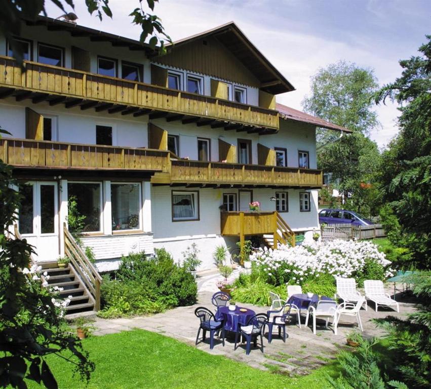 ein Haus mit Tischen und Stühlen im Hof in der Unterkunft Gästehaus Eckstein in Oy-Mittelberg