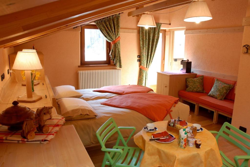 sypialnia z 2 łóżkami, stołem i krzesłami w obiekcie Affittacamere Lou Ressignon w mieście Cogne
