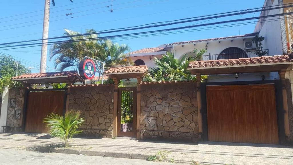 a house with wooden doors and a fence at Hotel el super 8 in Santa Cruz de la Sierra