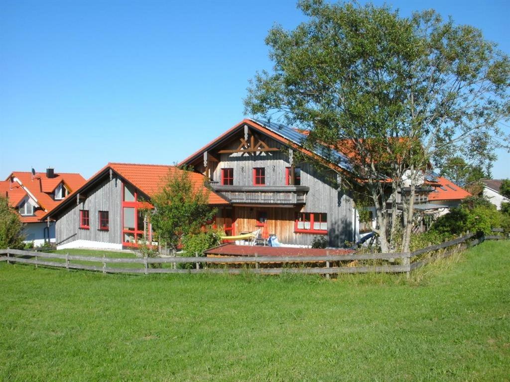 une grande maison avec une clôture en face d'un champ dans l'établissement Ferienwohnung Klaus, à Oy-Mittelberg