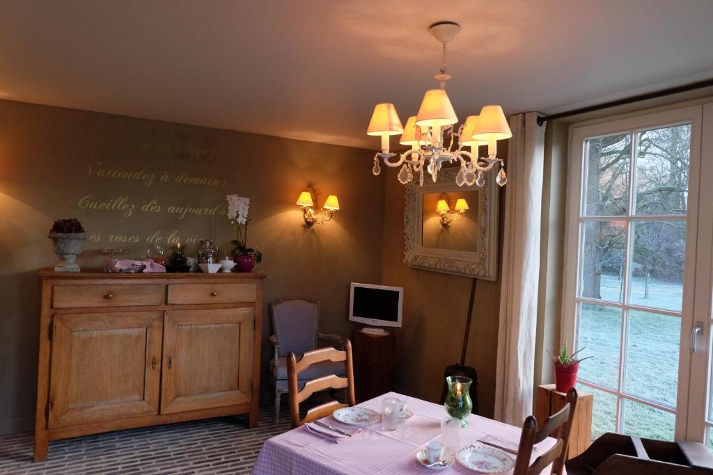 a dining room with a table and a chandelier at B&amp;B Asbeek in Asse
