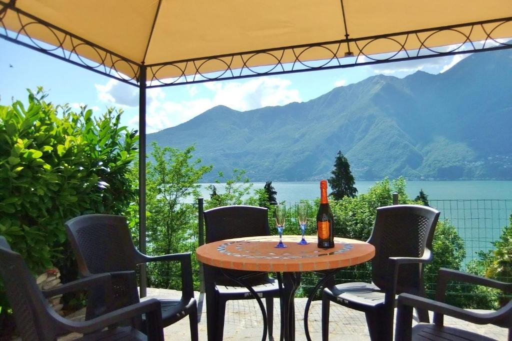 stół z krzesłami i butelkę wina w obiekcie Casa le Palme w mieście Pino Lago Maggiore