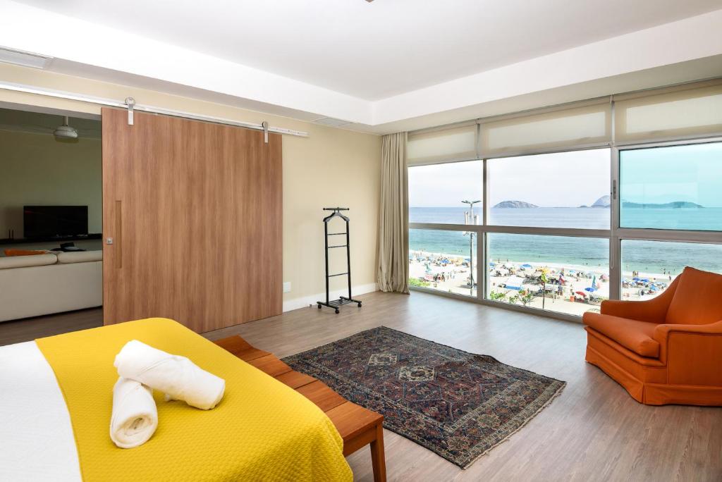 a bedroom with a yellow bed and a view of the beach at Vista para o mar em Ipanema - VS401 Z1 in Rio de Janeiro