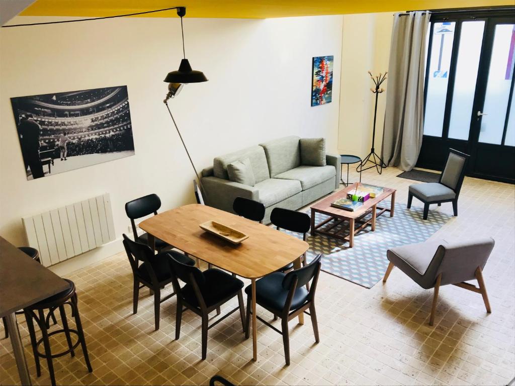 Hôtel Villa Blomet في باريس: غرفة معيشة مع أريكة وطاولة وكراسي