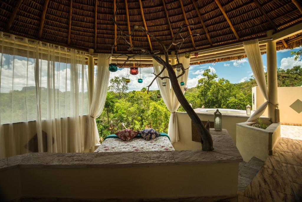 um quarto com uma cama num quarto com janelas em Jalapão Ecolodge em São Félix do Tocantins