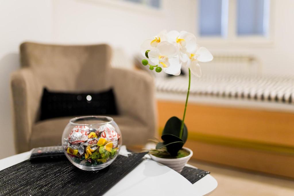 a small glass bowl with a flower on a table at Hostel Herz in Banja Luka
