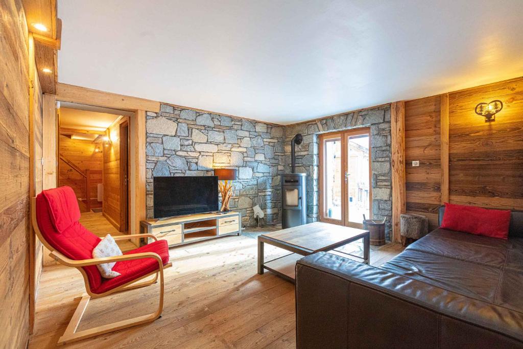 a living room with a couch and a stone wall at Appartement Marcella in Montgenèvre
