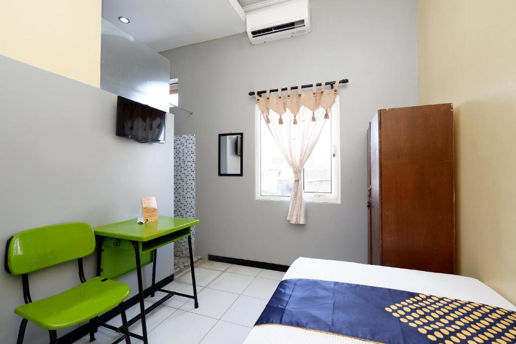 Postel nebo postele na pokoji v ubytování SUPER OYO 2209 Solo Point Guest House Syariah