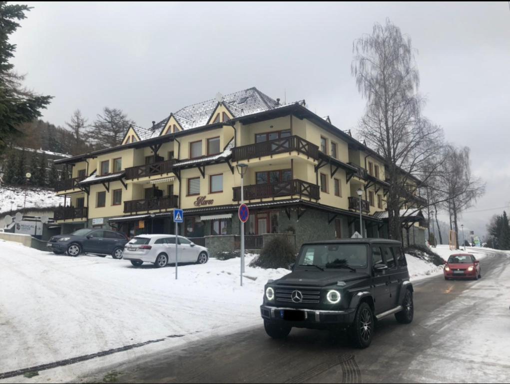 een oude auto die door een straat voor een gebouw rijdt bij Apartment Olivia in Donovaly