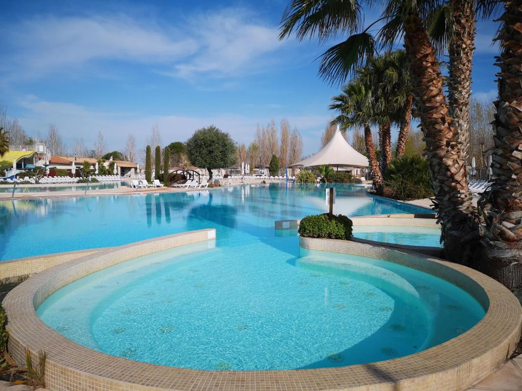 - une grande piscine d'eau bleue dans un complexe dans l'établissement Meublé de tourisme 6/8 pers bord de mer sur camping 4*, à Vias