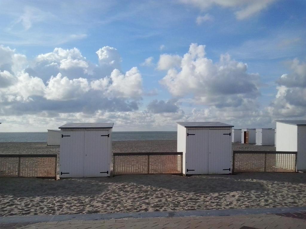 eine Reihe von Strandhütten am Strand in der Unterkunft Mijana in Knokke-Heist