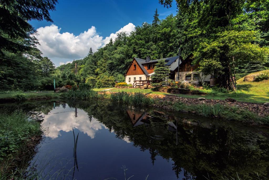 a house in the woods next to a river at Ferienhaus Jägerhaus Oppach Privathaus in Oppach