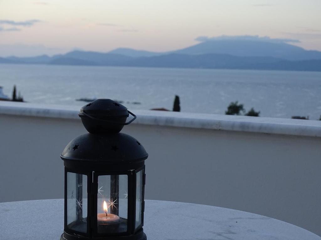a lantern with a candle in it sitting on a wall at Villa ADA in Hydra