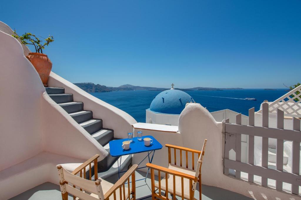 a set of stairs with a blue table and chairs at De Profundis by Thireon in Oia
