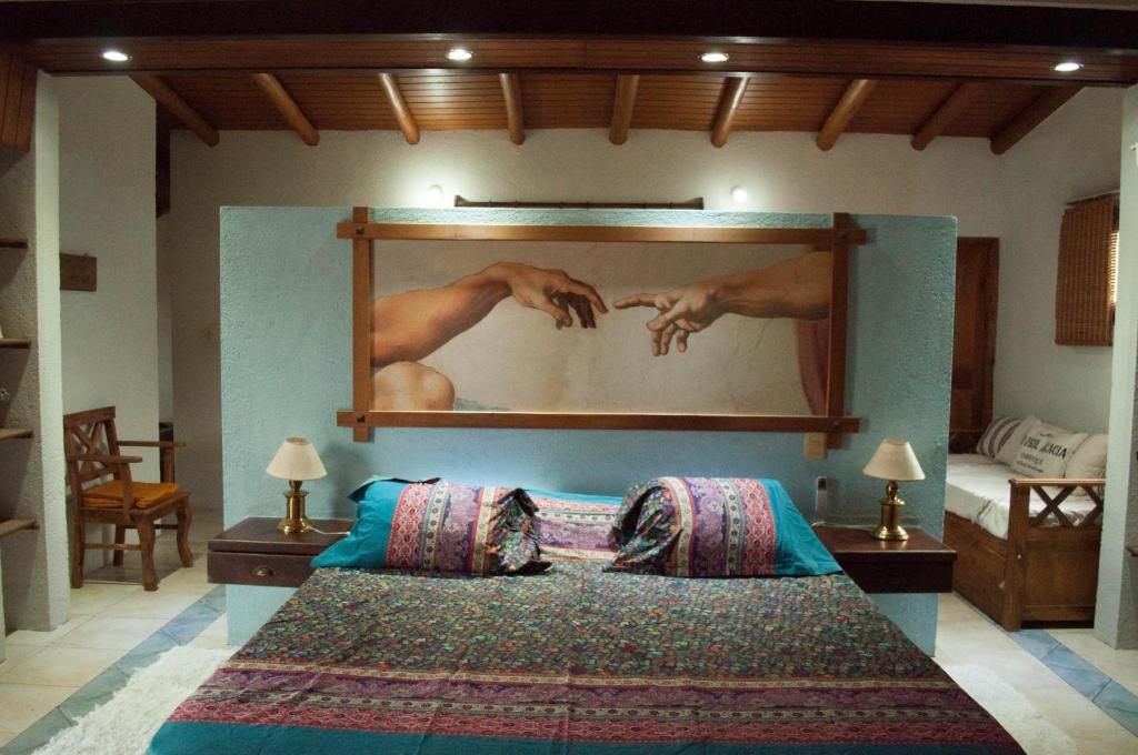 1 dormitorio con 1 cama y una gran pintura en la pared en Casa Villa en Córdoba