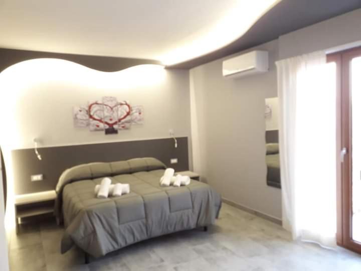 1 dormitorio con 1 cama con 3 almohadas en B&B Donjon centro, en Castelbuono
