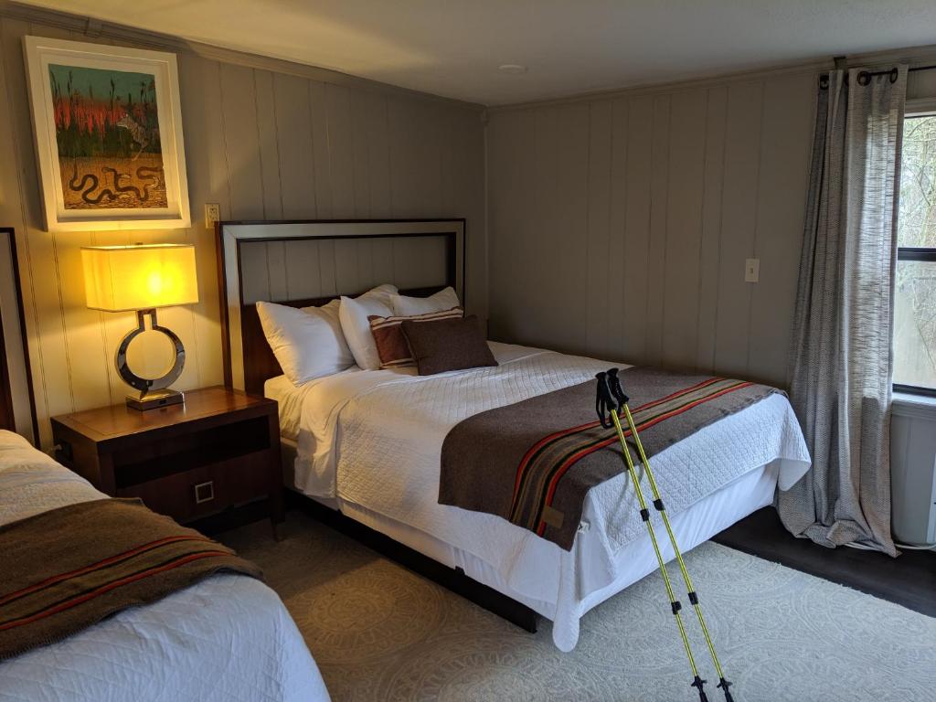 a bedroom with two beds and a lamp and a tripod at Loblolly Pines Adventure Cabin 1 Q/Q in Eureka Springs