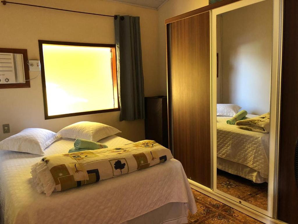 una camera con due letti e uno specchio di casa temporada a Parati