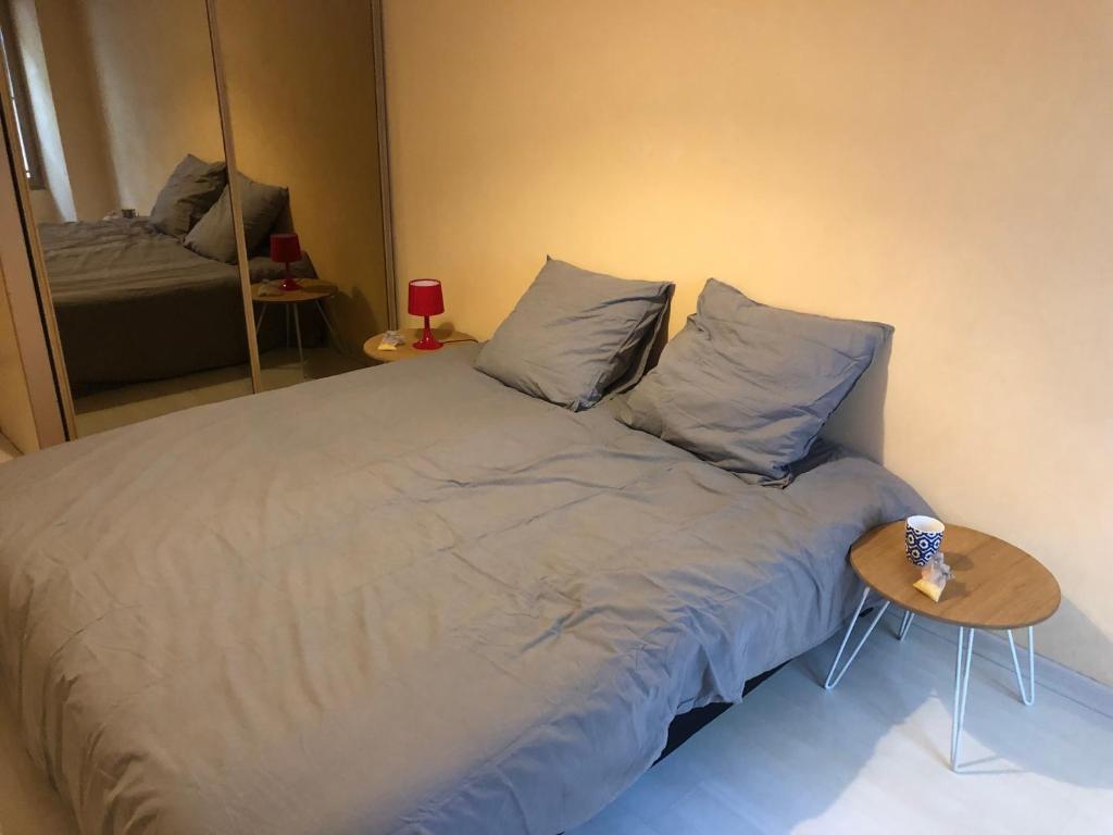 1 dormitorio con 1 cama con mesa y espejo en Magnifique appartement tout équipé - 6 personnes, en Le Puy en Velay