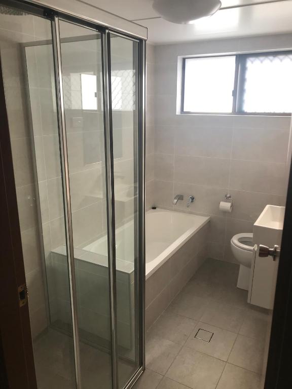 a bathroom with a shower and a tub and a toilet at Breakers 3 - linen not included in Forster