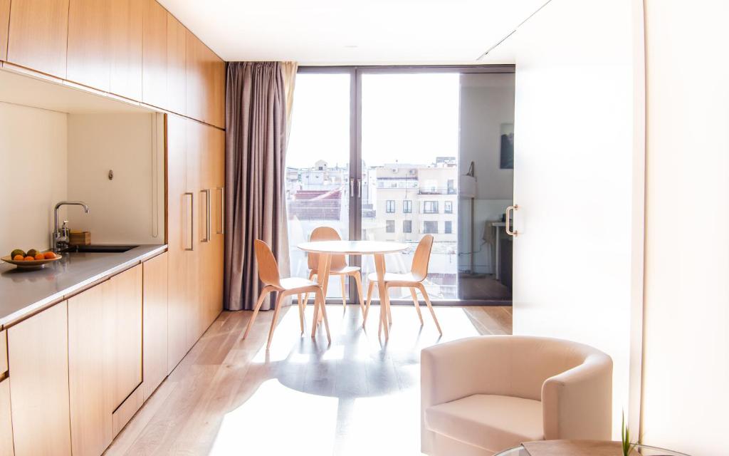 una cucina e una sala da pranzo con tavolo e sedie di Hoom Apartments Juan Bravo a Madrid