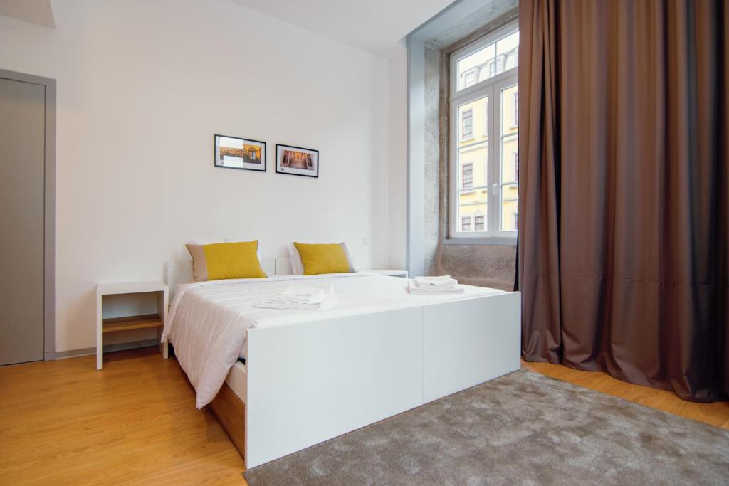 1 dormitorio con cama blanca y ventana en HI Braga - Pousada de Juventude, en Braga