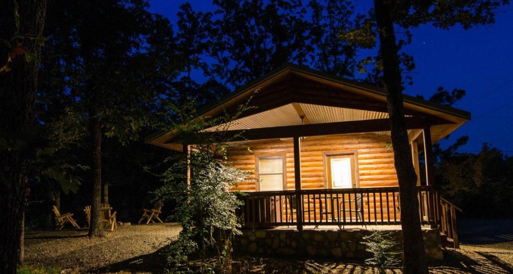 a log cabin with a porch at night at Sunsettin Cabin Free Parking Onsite in Stephens Gap