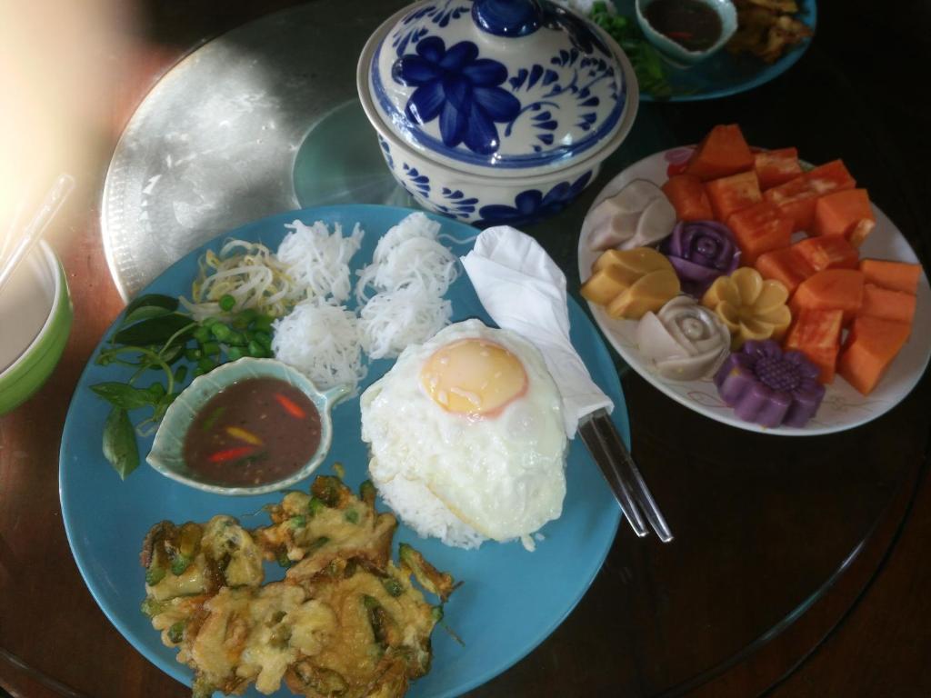 une table avec une plaque de nourriture sur une table dans l'établissement ต้งโฮมหละปูน ณ ตูบแก้ว, à Lamphun