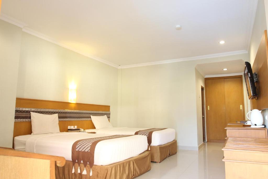 Postel nebo postele na pokoji v ubytování Cakra Kembang Hotel