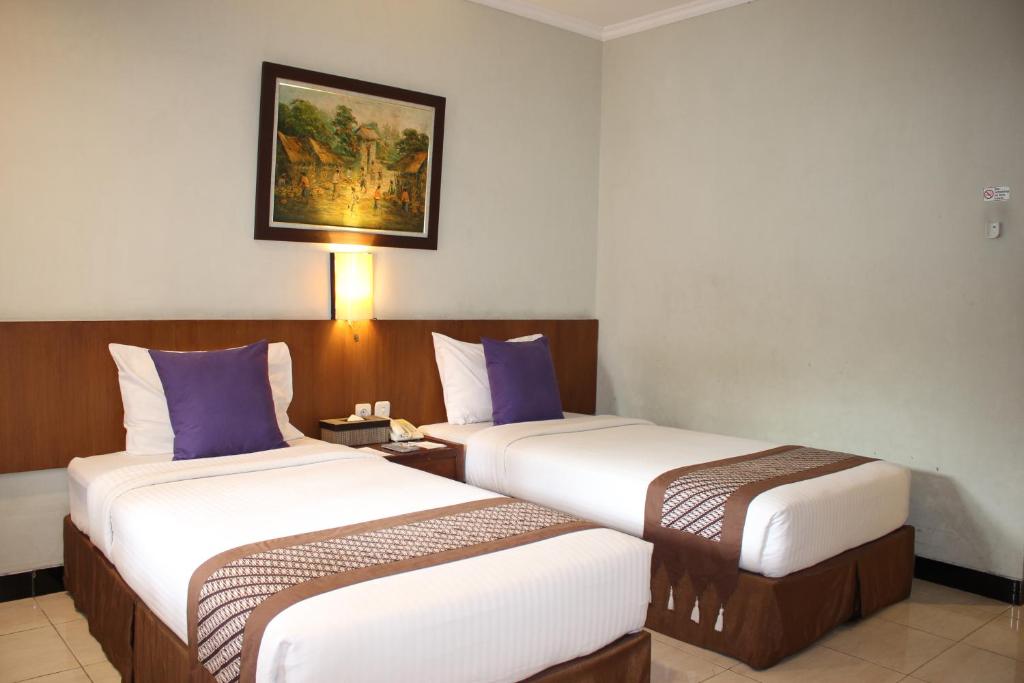 Postel nebo postele na pokoji v ubytování Cakra Kembang Hotel