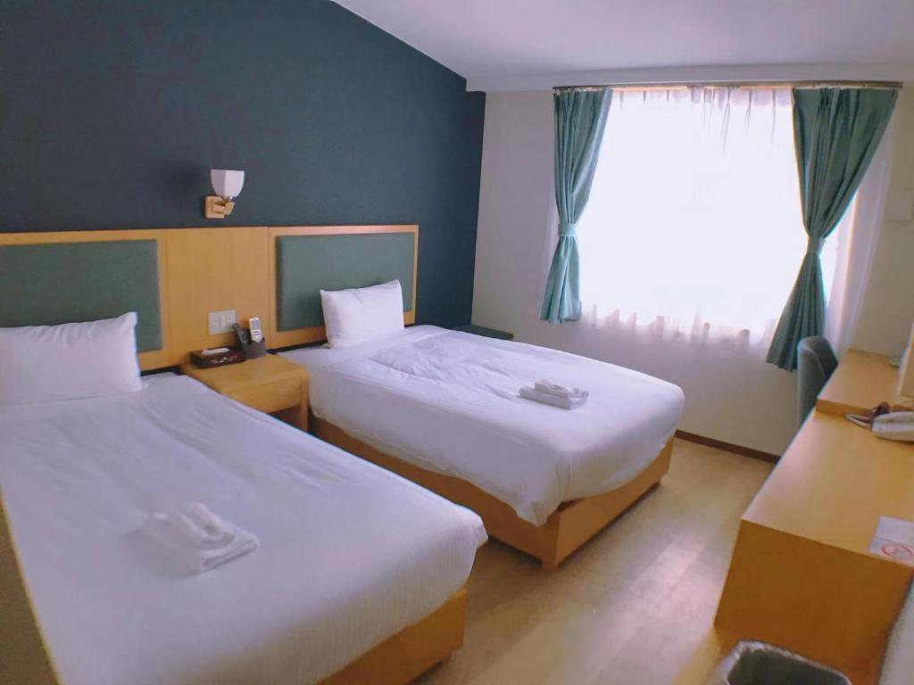 Postel nebo postele na pokoji v ubytování Fujinomori Hotel