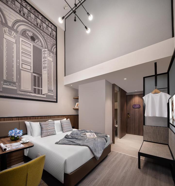新加坡Citadines Rochor Singapore的一间卧室，配有一张床、一张桌子和一把椅子