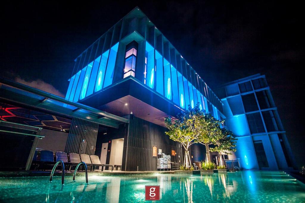 ein Gebäude mit Swimmingpool in der Nacht in der Unterkunft EXPRESSIONZ KLCC BY G Suites in Kuala Lumpur