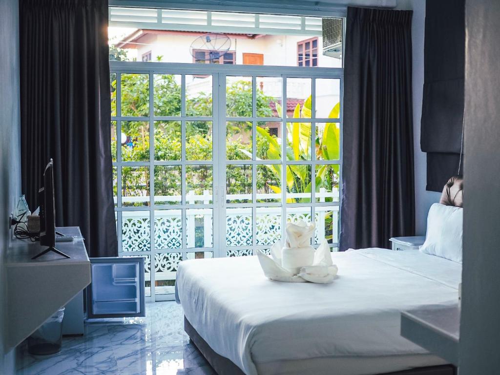 a hotel room with a bed and a large window at Promporn Boutique Hotel in Nan