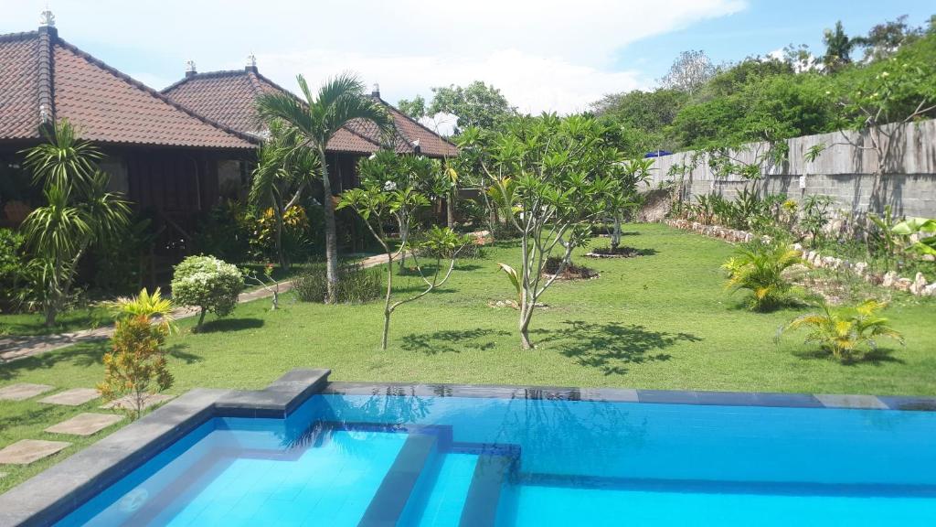 uitzicht op een zwembad in een tuin bij Gatri Hut in Nusa Lembongan